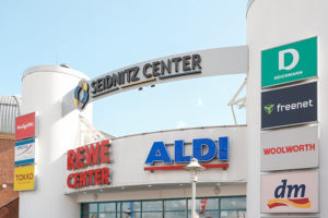 Über dem Haupteingang des Seidnitz Centers ist das Logo platziert, umgeben von den Logos einiger Shops.